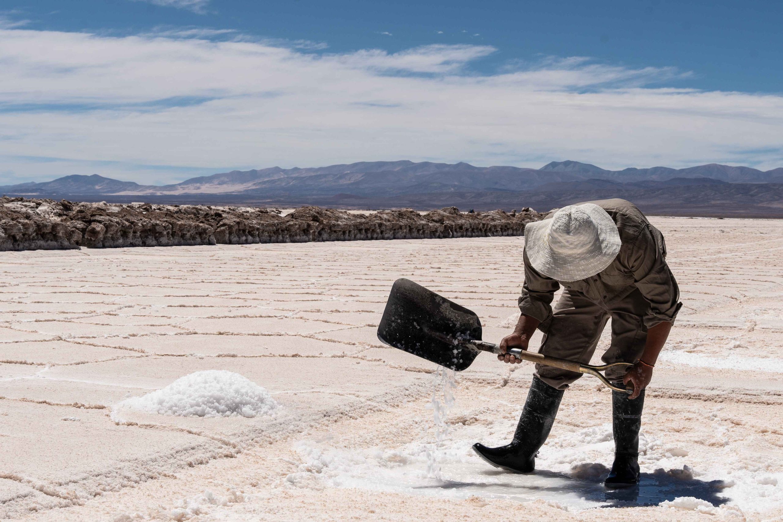 Man using a shovel in a salt production facility