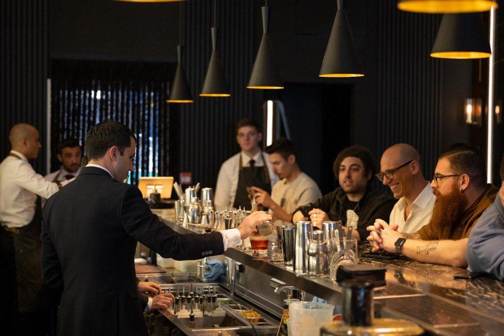 barman preparing a cocktail while watched