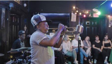 a trumpetist playing inside of a bar