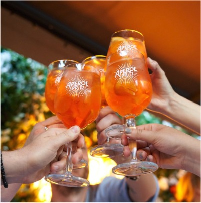 People raising Aperol glasses