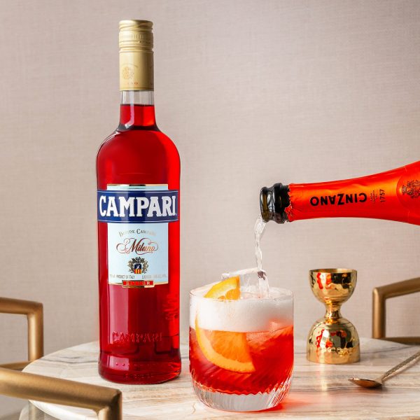 A glass of prosecco pours into a Negroni Sbagliato