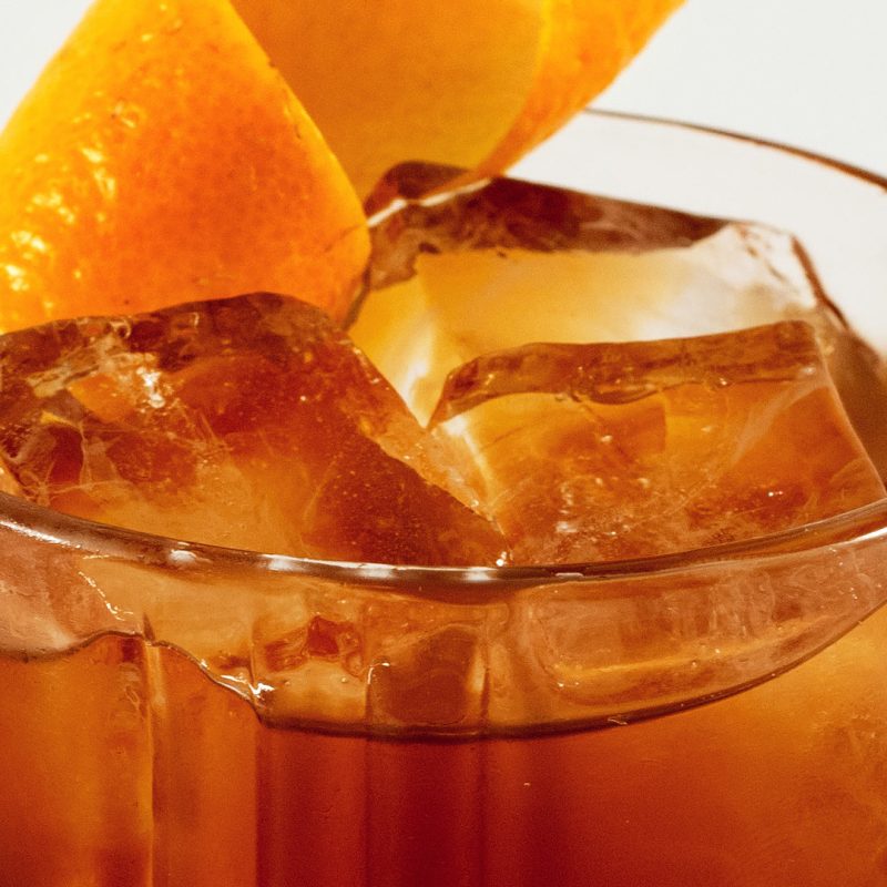 Photograph of a zoomed in cocktail and orange twist