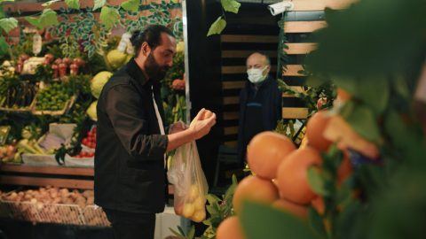 Man chooses fruits in a supermarket