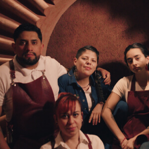 group of bartenders sitting in front of a brown wall