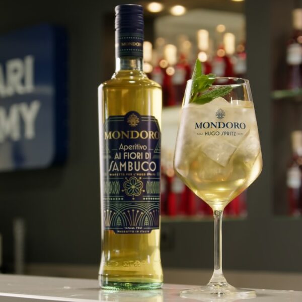 Copa de Mondoro Hugo Spritz, junto a una botella de Mondoro